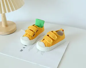 Vue détaillée des chaussures en toile jaune pour enfants avec embouts en caoutchouc et velcro