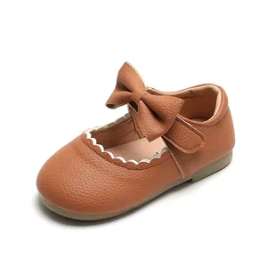 Toddler girl tan Mary Jane shoes with large bow and white scalloped trim detail