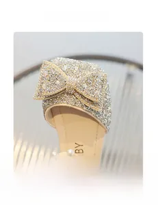 Détail d'une chaussure de princesse pour fille avec nœud en cristal et perles