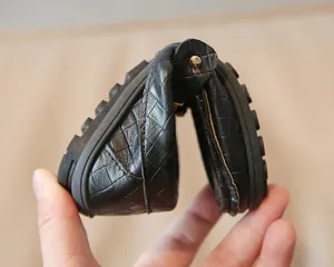 Détail de mocassins souples en cuir tressé noir avec semelle en caoutchouc pliable