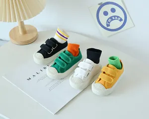 Détail de chaussures en toile pour enfants en quatre couleurs avec brides velcro et embouts