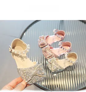 Détail de chaussures pailletées pour filles avec grand nœud et bride à la cheville