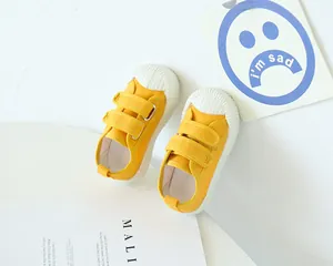 Détail de chaussures en toile jaune pour enfant avec velcro et embout en caoutchouc