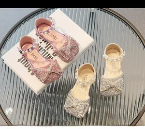 Détail de chaussures de princesse roses à paillettes avec nœud et bride en perles