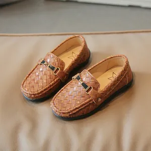 Mocassins tressés marron pour enfants avec boucle métallique sur fond de texture cuir
