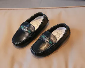 Detail von Kinder-Slippern aus schwarzem Lackleder mit Streifen und weicher Sohle