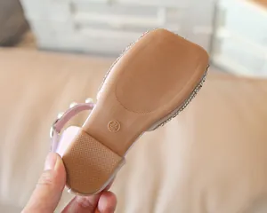 Détail de la semelle en caoutchouc antidérapante et de la bride perlée pour sandales