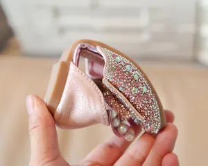Gros plan sur la chaussure souple rose pour fille avec perles et semelle en caoutchouc