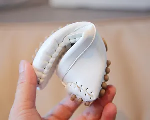 Nahaufnahme der hohen Flexibilität und weichen Gummisohle weißer Kinder-Loafer