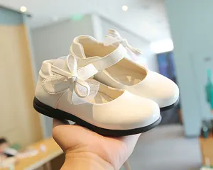 Detail of white patent leather Mary Jane shoe with mesh bow and durable rubber sole