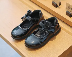 Detail shot of black patent leather Mary Jane shoes with double bow and quilted insole