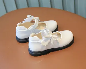 Detailed view of girls' white Mary Jane shoes featuring a lace bow and soft anti-slip sole