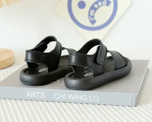 Détail de sandales noires pour enfants avec scratch et semelle épaisse souple