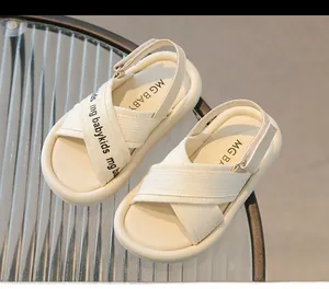 Dettaglio di sandali per neonati color crema con suole morbide e cinturini in velcro sopra