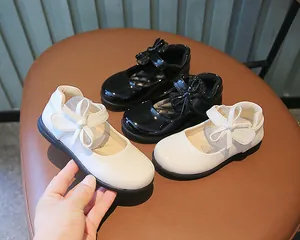 Close-up of white Mary Jane shoes for girls featuring a decorative layered bow