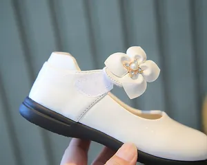 Vue détaillée des chaussures Mary Jane blanches avec fleurs 3D et perles