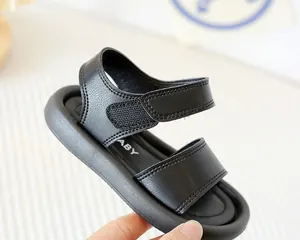 Détail de sandale noire pour enfant en cuir PU avec fermeture velcro et semelle souple