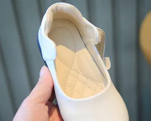Détail des chaussures Mary Jane blanches montrant la semelle intérieure matelassée pour fille