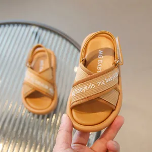 Dettaglio di sandali estivi per bambini color kaki con cinturini e chiusura a strappo