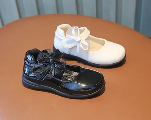 Close-up of girls Mary Jane shoes with bow decoration and mesh detail on leather