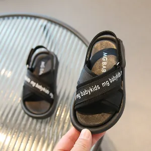 Dettaglio dei sandali estivi neri per bambini con cinturino in velcro e suola in gomma