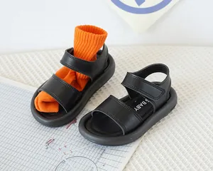 Détail de sandales noires pour enfants avec double velcro et semelles souples épaisses