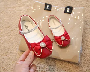 Vue détaillée de chaussures Mary Jane rouges avec nœud en soie et décor de perles