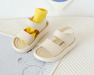 Détail de sandales enfant crème avec double bride velcro et semelle souple épaisse