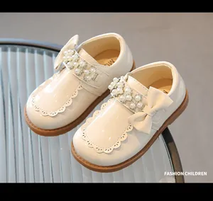 Close-up of pearl and rhinestone details on cream patent leather girls princess shoes