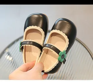 Detail of girls' Mary Jane shoes with cream scalloped edges and green sunflower buckle