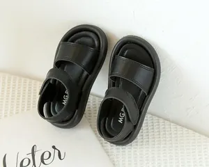 Gros plan sur les sandales noires pour enfants avec double brides et semelles souples