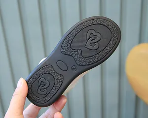 Detailed macro view of black non-slip rubber shoe sole with size 28 and heart patterns