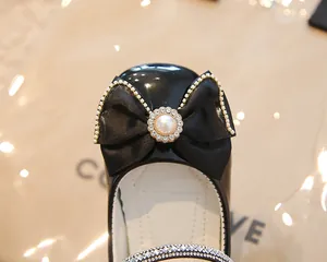 Détail de ballerines Mary Jane noires vernies pour filles avec nœud en satin et perle