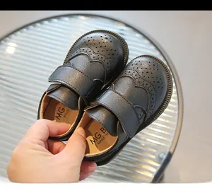 Detailed close-up of retro black kids brogue shoes featuring velcro strap and hole punching