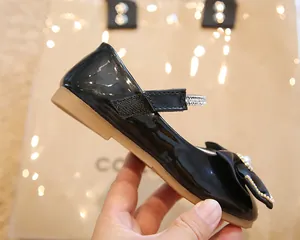Détail de chaussures Mary Jane noires vernies pour filles avec nœud en soie et perles
