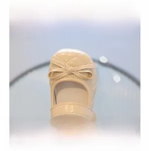 Détail de ballerines beiges pour filles avec motif matelassé, nœud et embout de protection