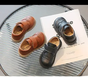 Detailed shot of retro British style kids leather shoes with velcro and brogue perforations