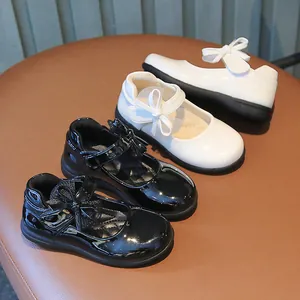 Girls' patent leather Mary Janes with bow detail in classic black and white colors