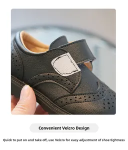 Detail of children's black leather shoes with Brogue carving and Velcro strap