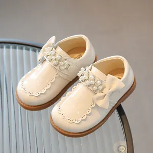 Girl's cream white patent leather Mary Jane shoes with pearl bow and rhinestone details