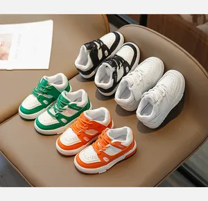 Détail de baskets rétro pour filles avec plateforme en noir, blanc, vert et orange