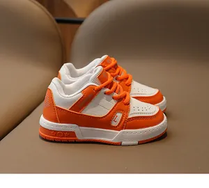 Gros plan de baskets pour enfants avec empiècements orange et blanc et semelle à étoiles