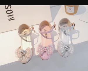 Détail de chaussures de princesse scintillantes pour filles en or, rose et argent avec strass