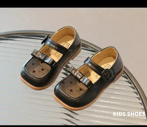 Detail of girls' black mesh sandals featuring heart patterns and cute bow accents