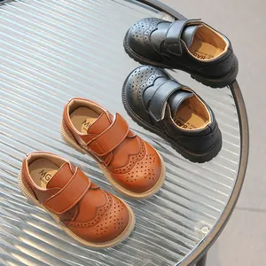 Classic British style kids' faux leather shoes in black and brown with brogue carving