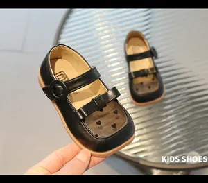 Detail of girls' black Mary Jane shoes featuring heart mesh panel and bow decoration