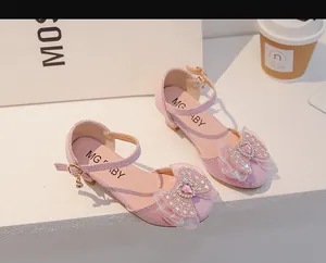 Détail de chaussures princesse roses pour filles avec cœur en strass et nœud