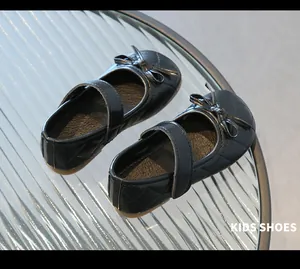 Détail de chaussures Mary Jane noires pour filles avec motif matelassé et nœud