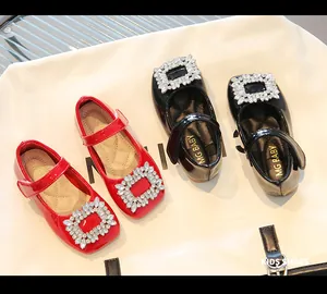 Detail of red and black patent leather mary jane shoes with sparkling rhinestone buckles