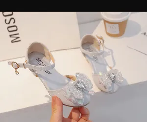 Détail de la chaussure princesse argentée avec strass en cœur et nœud décoratif